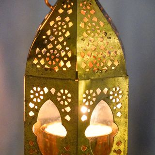 Green metal lantern with cut-out designs
